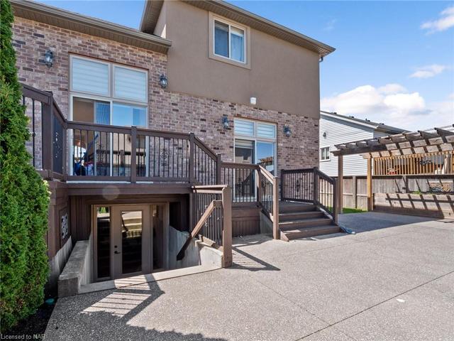 Bi-level wood deck with entrances from Kitchen and Great Room. Gas line for BBQ hook-up to the side of upper deck. Walk-up from Basement to backyard patio can be seen under the deck. Pergola on the west side of property. But wait...there's more! | Image 35