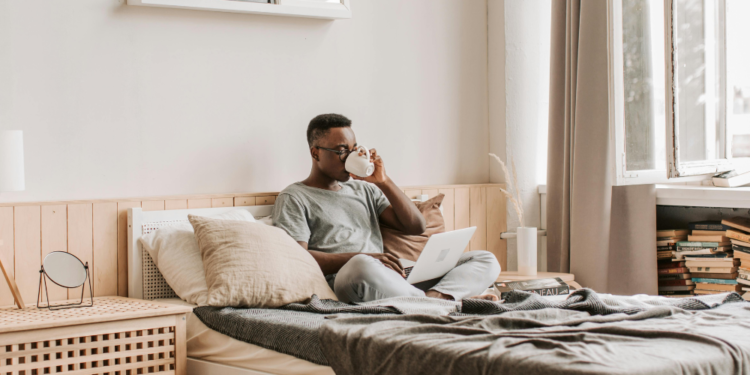 Person drinking coffee in a bed