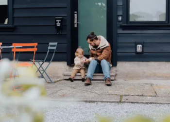 Dad playing with child in front of a house