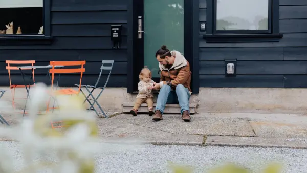 Dad playing with child in front of a house