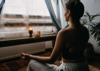 A woman meditating by a window