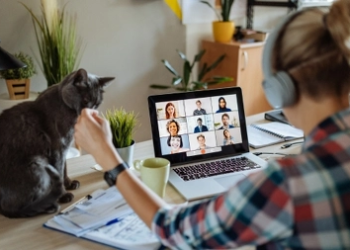 woman working from kitchen table with cat