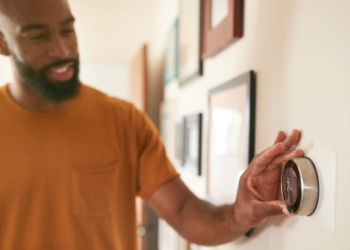 A man adjusting a smart thermostat