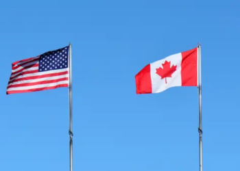 An American and Canadian flag blowing in the wind