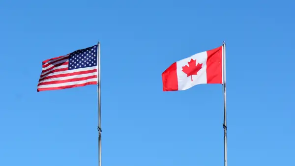 An American and Canadian flag blowing in the wind