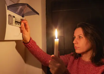 A woman holding a candle in the dark during a power outage