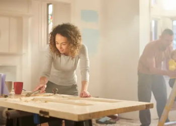 Two people working on fixing up a house.