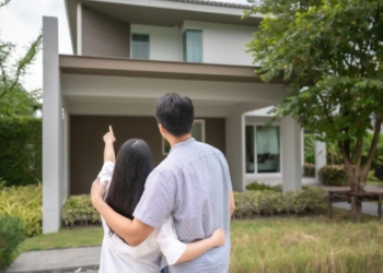 a couple looking at the exterior of a house