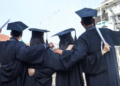 Four college graduates in their cap and gowns