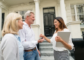 Two people talking to a real estate agent.