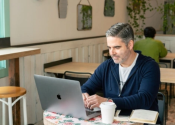 man on laptop in a coffee shop