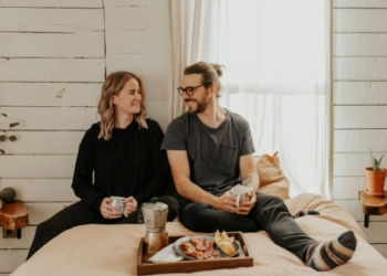 couple smiling eating breakfast in bed