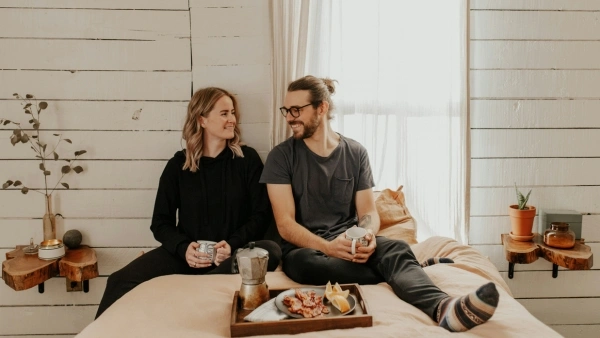 couple smiling eating breakfast in bed