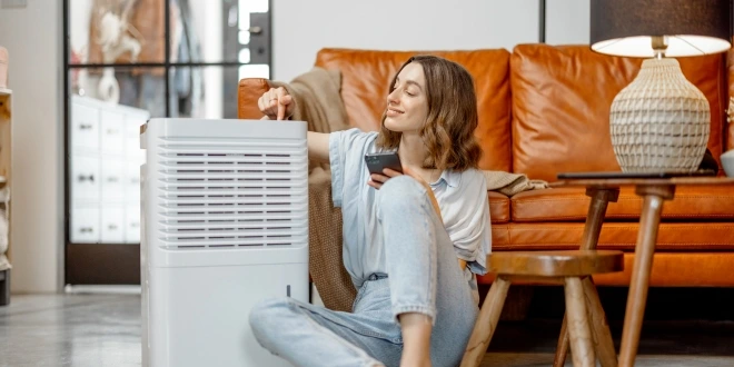 A woman sitting next to an air purifier