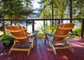 Two Muskoka chairs on a cottage deck